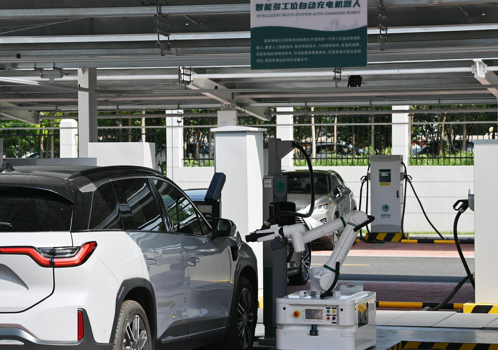▲2021年8月18日，天津，机器人正在为一辆新能源汽车充电。图/新华社
