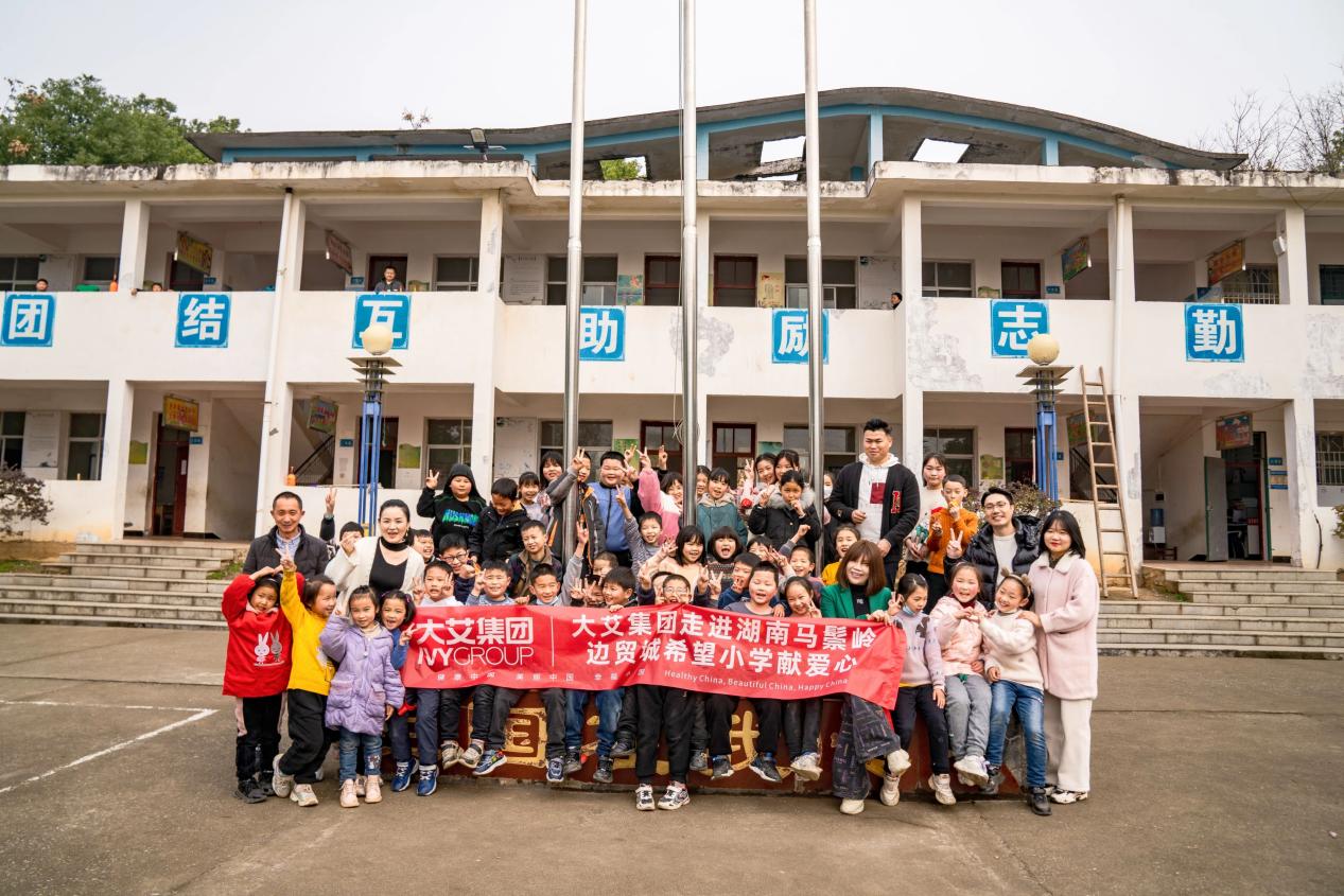 　　(覃华(右五)率领集团爱心基金会成员走进希望小学献爱心)