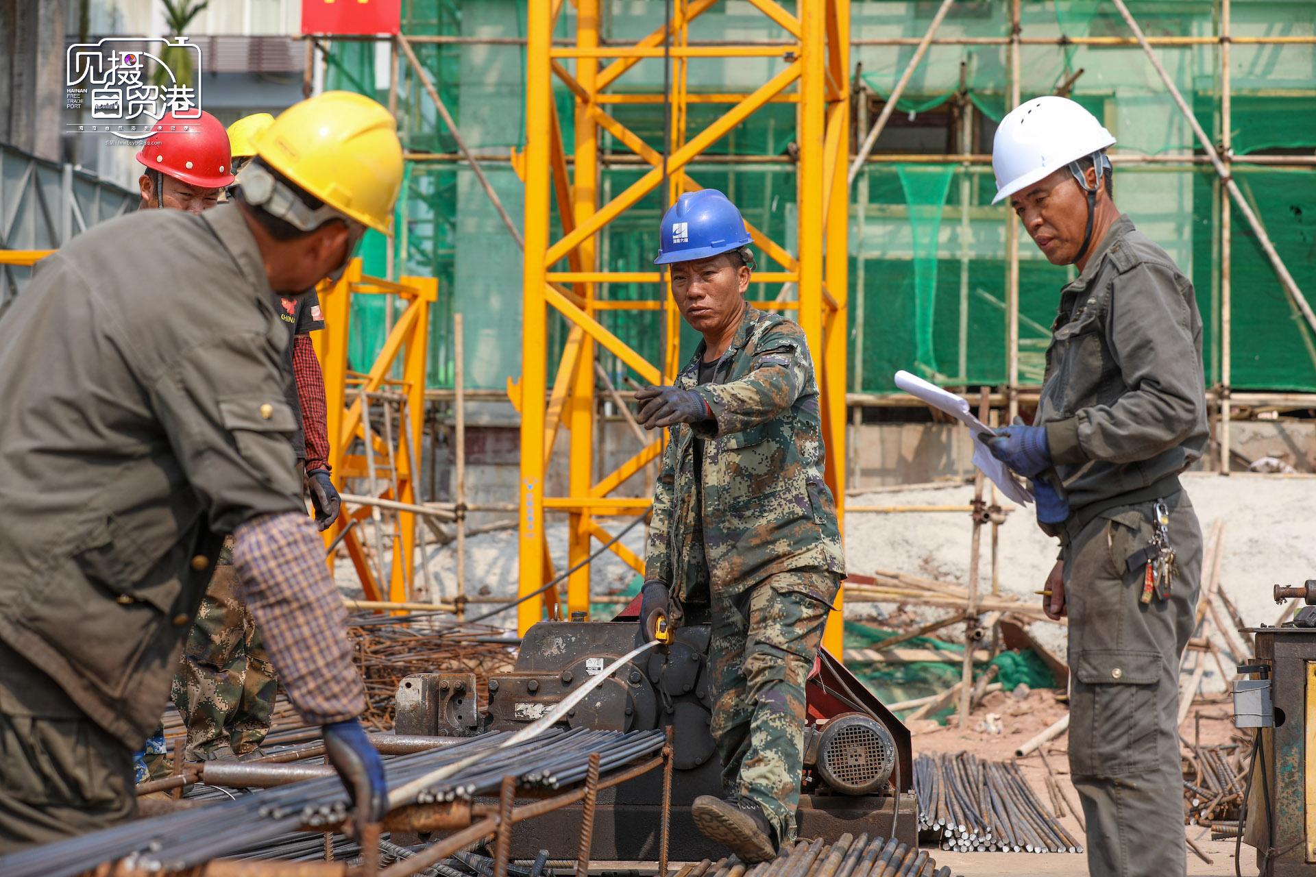 3月8日,在白沙黎族自治县智慧停车楼项目建设现场,工人测量钢筋长度