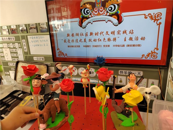 　　孩子们展示自己完成的手工捏面人作品,王二小和小英雄雨来分别在左边(戴草帽)和右边(拿枪)