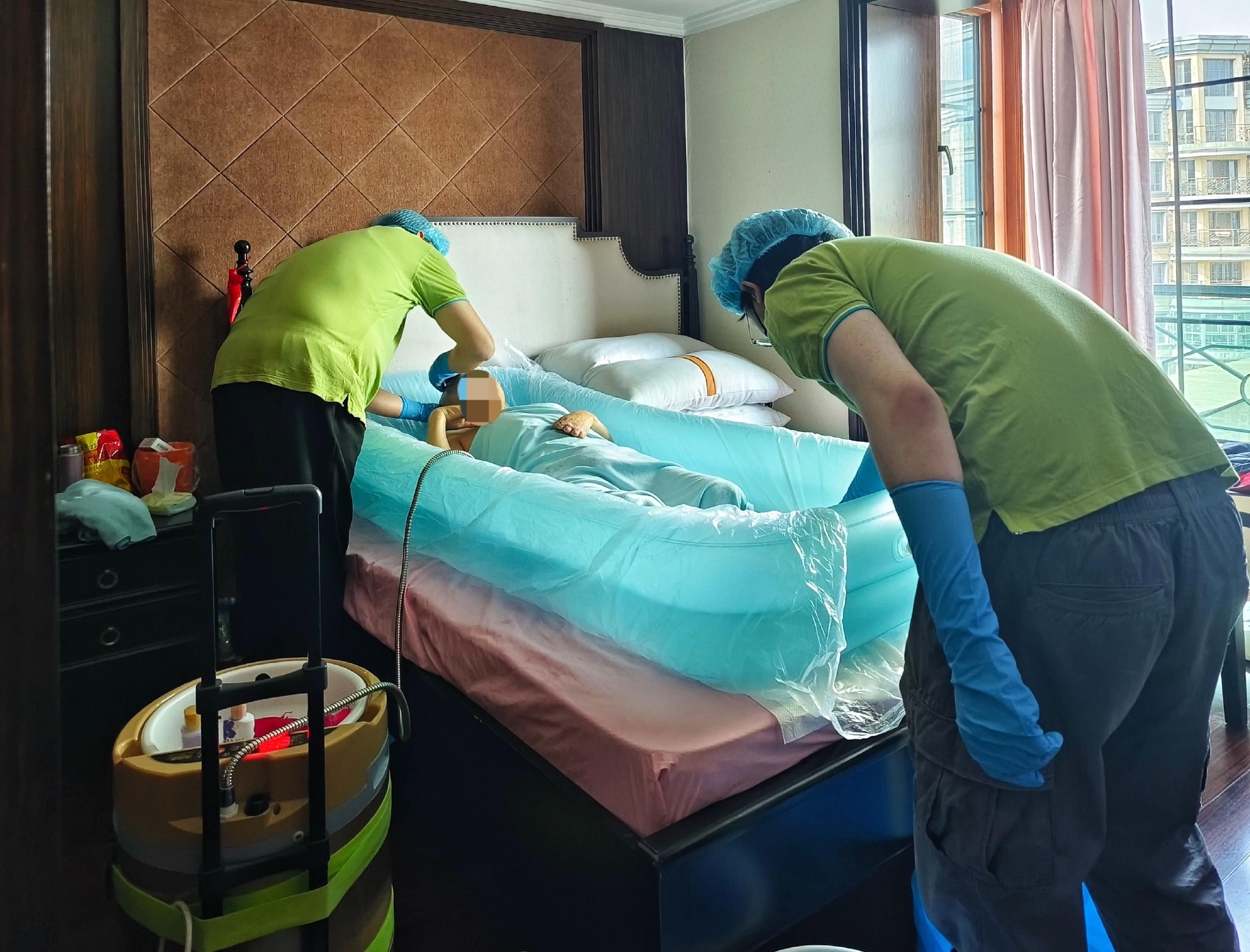 3月8日下午,助浴师在给刘金生洗澡,他躺在"床"上把澡洗了.受访者供图