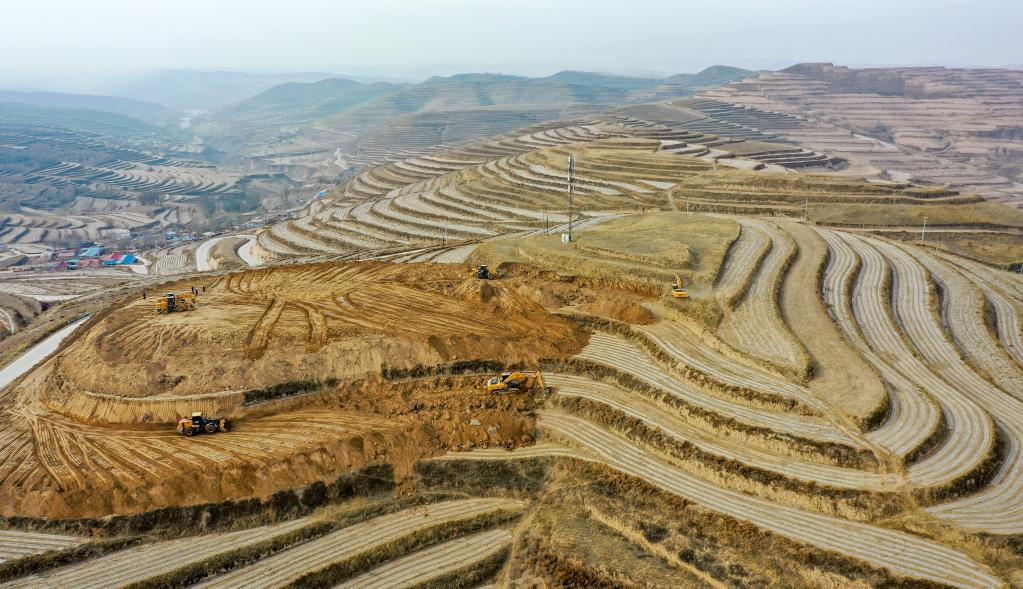 工人操作机械在宁夏固原市西吉县硝河乡苏沟村平整土地.