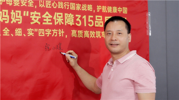 　　(图为袋鼠妈妈集团董事长徐小建先生在品质宣言旗帜上签名留影)