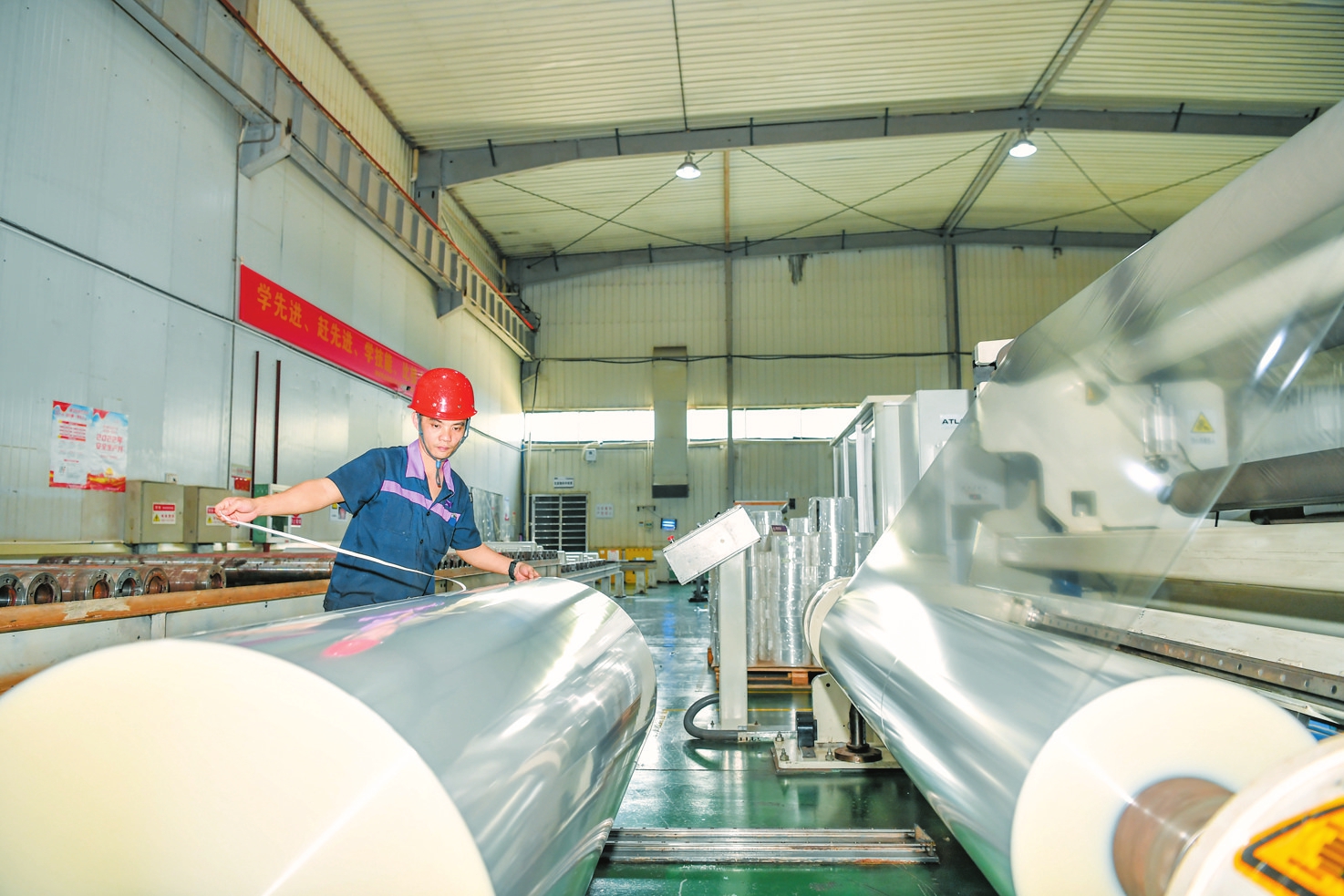 车间工作人员正将薄膜放入分切机