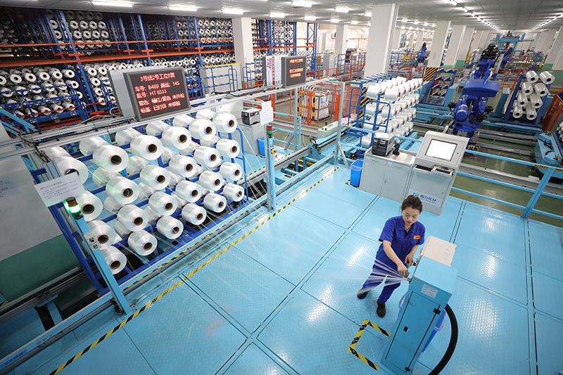 3月15日,在恒力(苏州)产业园内的高性能涤纶工业丝智能车间内,员工对