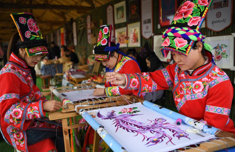 3月18日,宁强羌族刺绣的非遗传承人在2023中国最美油菜花海汉中旅游