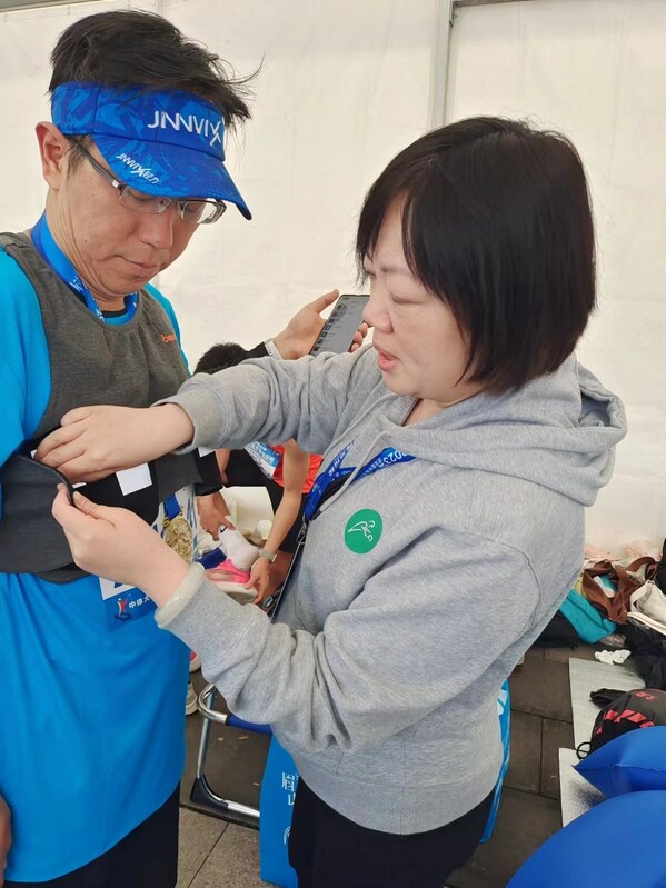 　　云鹊医工作人员为参赛选手穿戴智能心电衣
