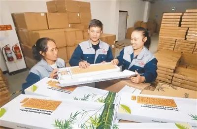 江西奔步科技有限公司工程师肖强（中）和工人在查看刚下线的竹键盘等产品。刘 凯摄