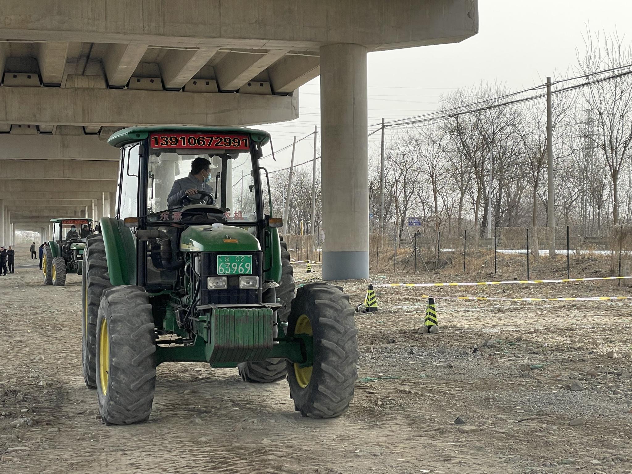 3月24日,在京郊的拖拉机驾驶资格考核现场,学员们正在练习"停车入库".