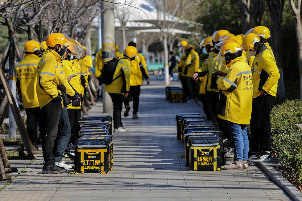 2023年3月13日,山东潍坊,美团外卖骑手在召开例会.图据视觉中国