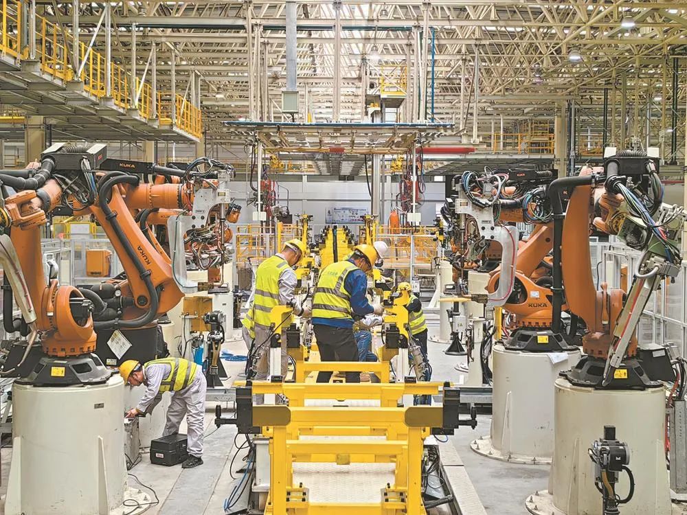 3月26日，东风汽车纳米科技有限公司焊装车间内，工作人员正在对机器人进行安装调试。严俊杰 摄 