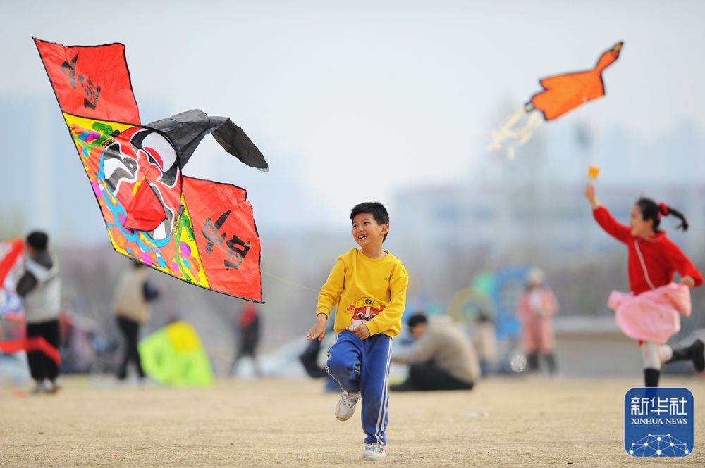3月26日,小朋友在山东省滕州市市民广场放风筝.新华社发(李志军 摄)