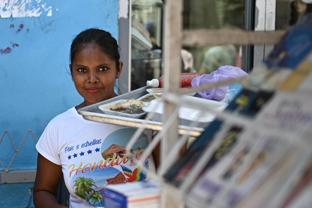 　　3月26日，一名女子在洪都拉斯首都特古西加尔巴的一处街道上售卖小吃。新华社记者辛悦卫摄
