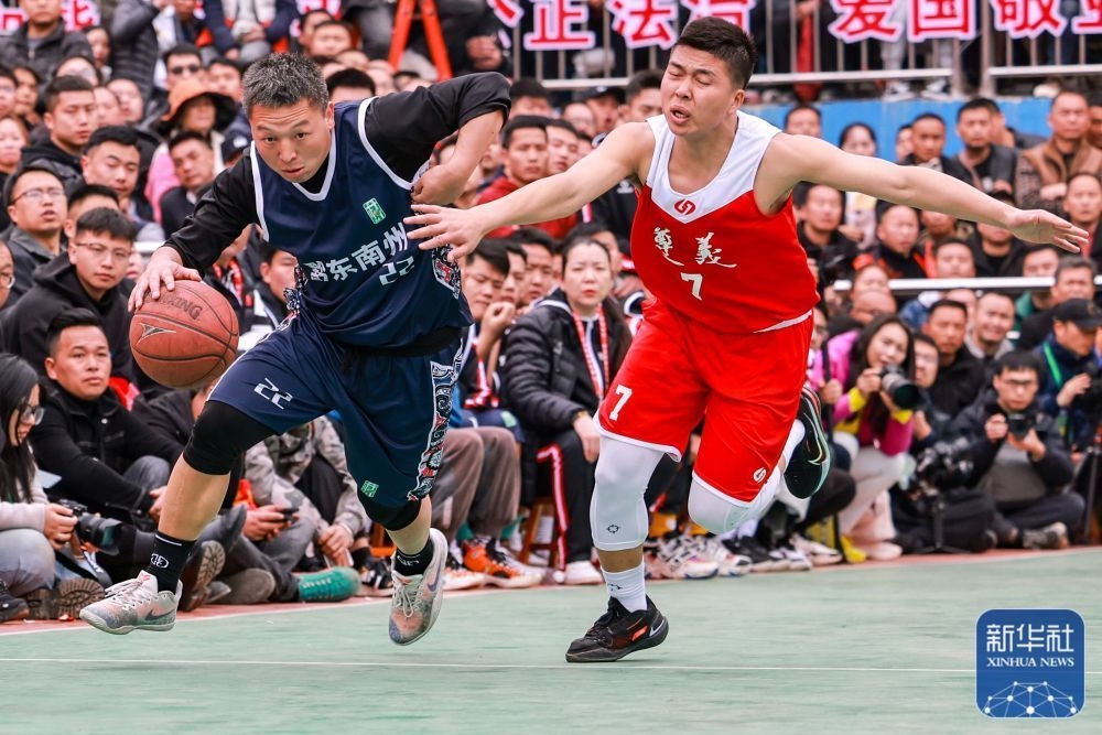 &uarr;黔东南州代表队球员欧明辉（左）在比赛中进攻。新华社记者 欧东衢 摄