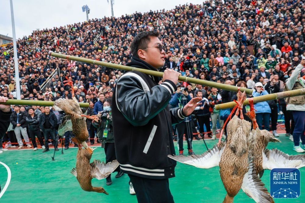 &uarr;村民挑着当地农特产品&ldquo;三穗麻鸭&rdquo;进入赛场。这是季军铜仁市代表队的奖品。新华社记者 欧东衢 摄