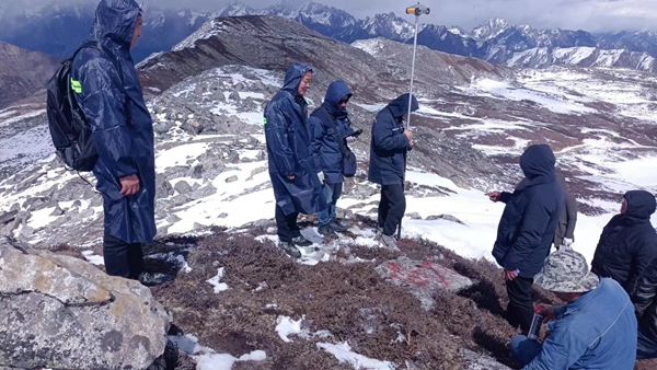 青海送变电线路复测人员顶风冒雪，在海拔4300米的现场进行桩位的测量工作。摄影：李冰