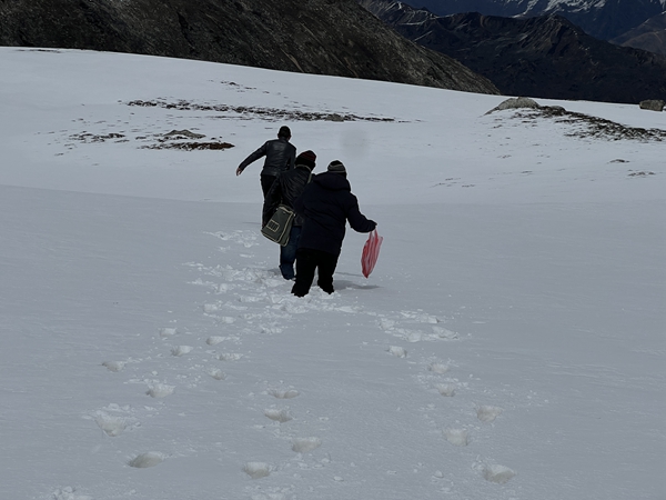 线路复测人员蹚过深度超过80厘米厚的积雪，艰难地向测量杆塔位前进。摄影：李冰