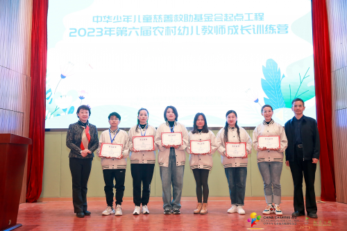 　　中华少年儿童慈善救助基金会副秘书长卫中(右一)与北京师范大学实验幼儿园总园长黄珊(左一)为往届优秀学员颁奖