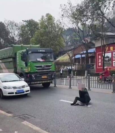 ↑男子坐在马路中间 据视频截图