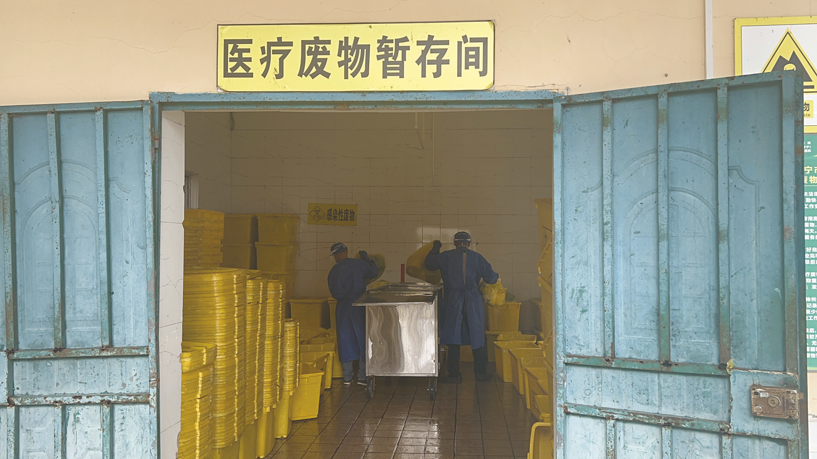     ▲南宁市第四人民医院医疗废物暂存间，工作人员正在将医疗废弃物装进箱子里