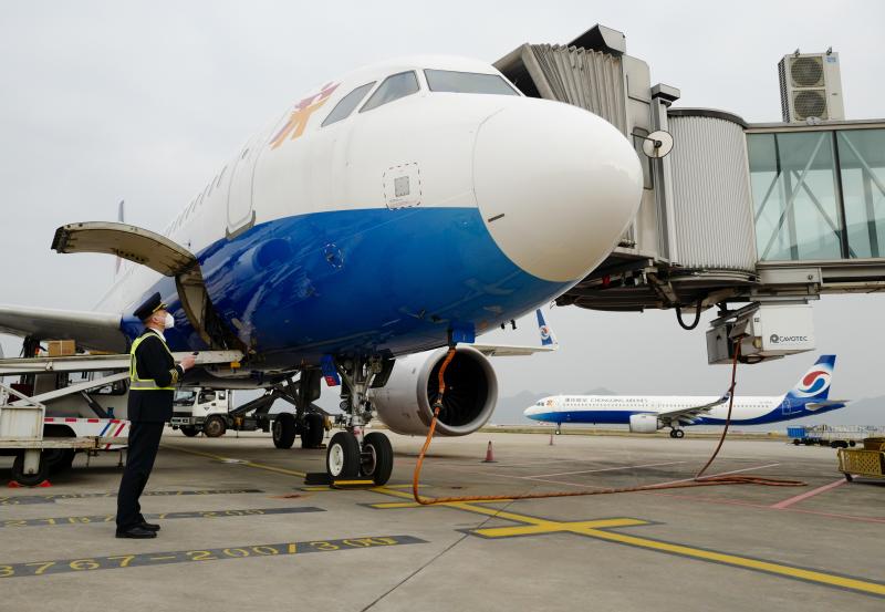 ▲1月6日，重慶江北國際機場的停機坪上，機長菅士博對客機進行起飛前的繞機檢查。圖/新華社