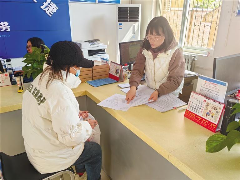 3月30日，陇县城关镇东城社区党群服务中心工作人员（右一）为办理业务的居民解释相关政策。 记者 甘甜摄