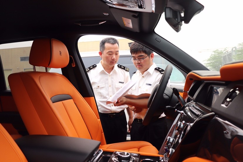 图为海口海关所属马村港海关关员现场监管入区参展汽车.(胡慧宣/图)