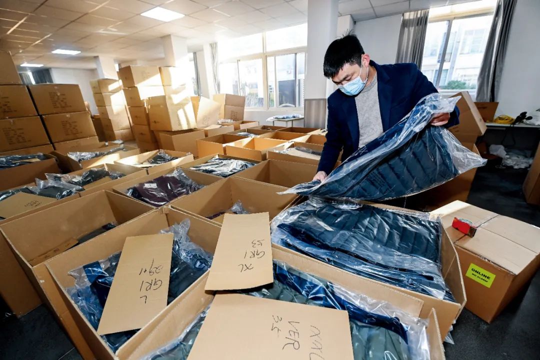 嘉兴市南湖创业园一家服饰公司的仓库内,工作人员在打包一批外贸服装