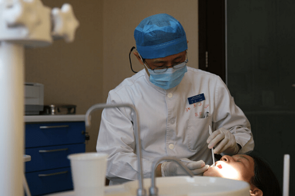 图为一名牙科医生正在进行口腔治疗。