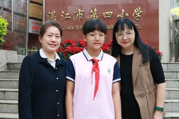 邓洁滢与班主任林芳老师（左）陈春艳校长（右）合影