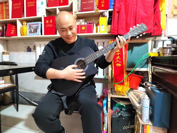 图为赵立彬有时会弹弹吉他,以缓解疲劳,振奋精神
