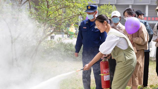 学生正在消防员的指导下使用灭火器.海淀区消防救援支队供图