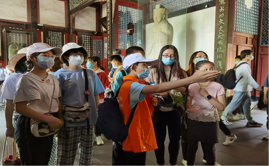 在都江堰景区,青少年志愿者正给游客做讲解,宣传文明旅游理念