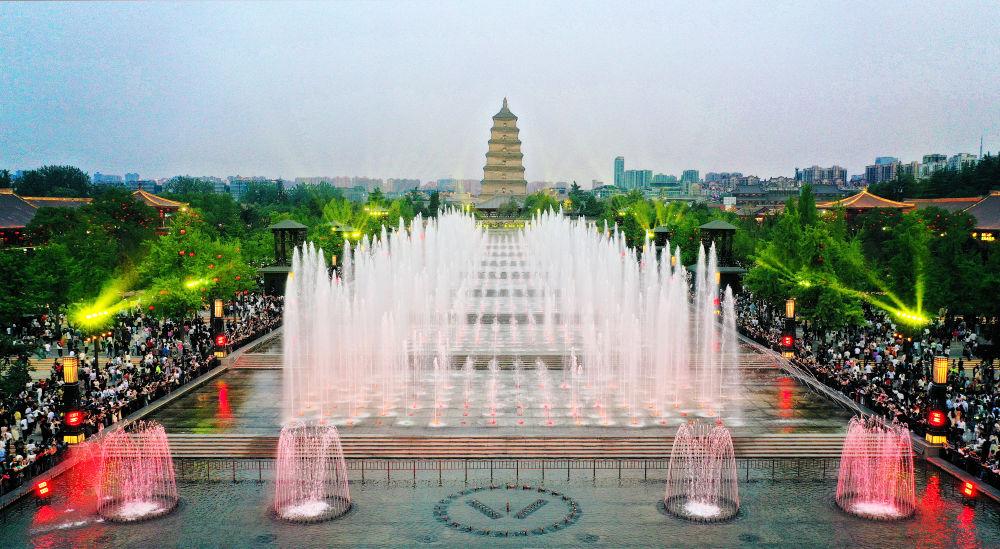 游人在西安大雁塔北广场观看音乐喷泉表演(4月18日摄,无人机照片).