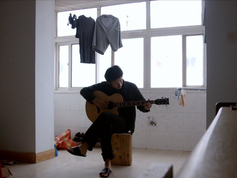 2004年，胡安焉在燕郊王各庄住所内弹吉他  受访者供图