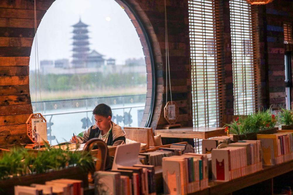 4月22日,一名小读者在江苏省扬州市运河三湾公园内的城市书房阅读.