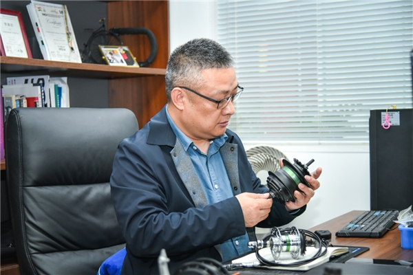 ▲李董的办公桌上放着各式变速器产品，以便随时拿取研究