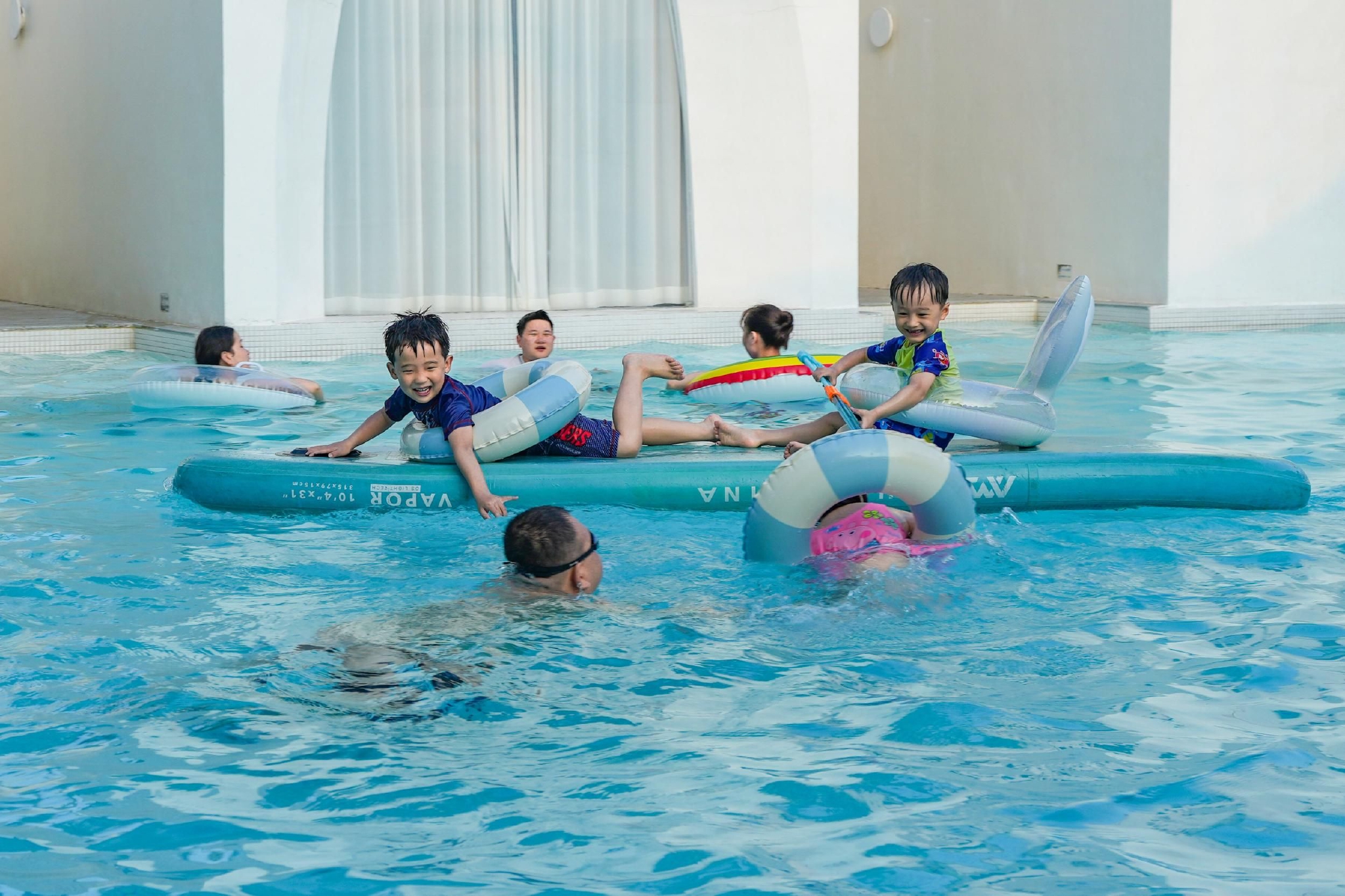 4月24日,在三亚市博后村若逸民宿,游客带着小朋友在泳池内开心玩耍