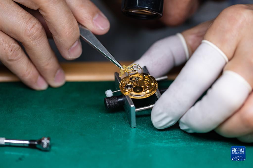 4月25日，在位于深圳的飞亚达钟表大厦，刘中华为一块手表安装摆轮部件。新华社记者 毛思倩 摄