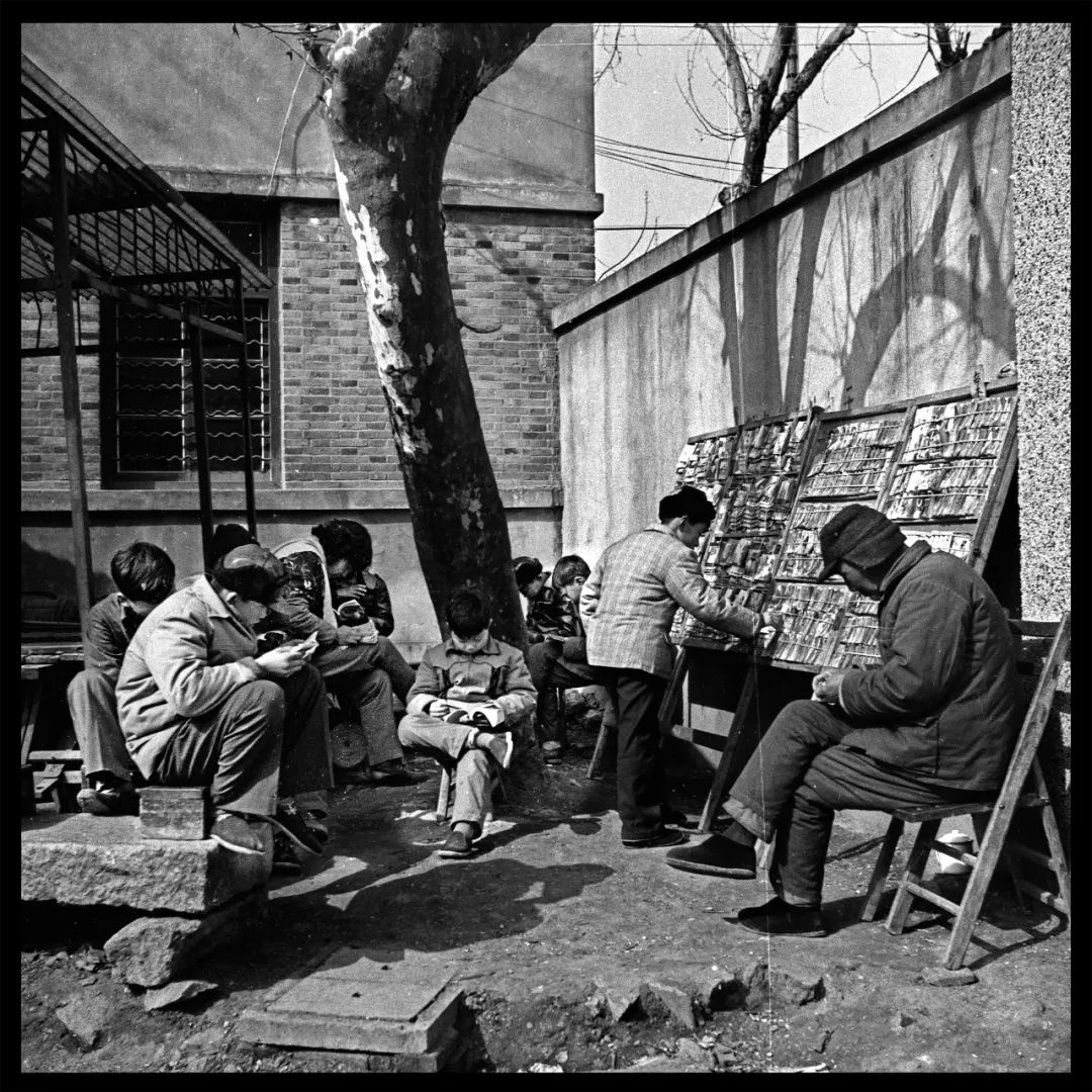 孩子们围坐一起看小人书.摄于八十年代崇福县街.