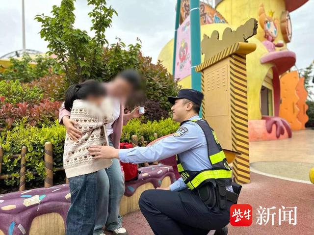 图为南京栖霞公安分局栖霞派出所民警在欢乐谷景区周边帮助走失女孩找到家人