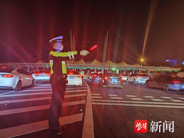 图为南京三桥公安检查站警力在主线收费站执勤点引导车流有序通过收费道口