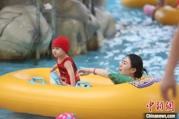 家长陪着小朋友在宁夏银川一水上乐园内戏水. 于晶 摄