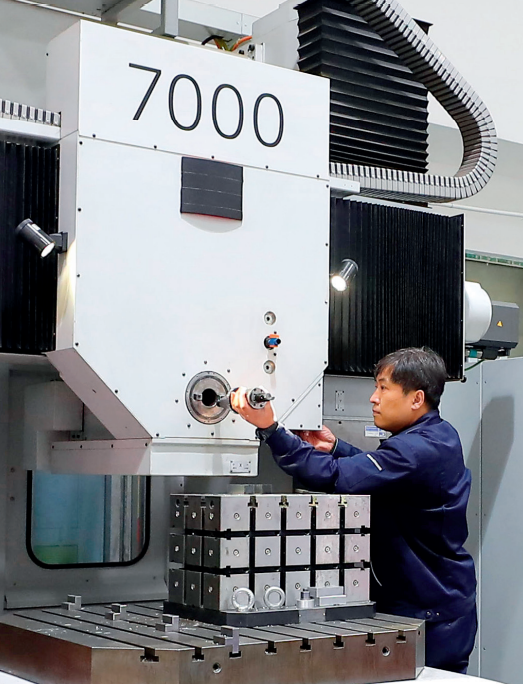 "罗阳青年突击队"成员王刚在航空工业沈飞车间操作数控镗床(2022 年