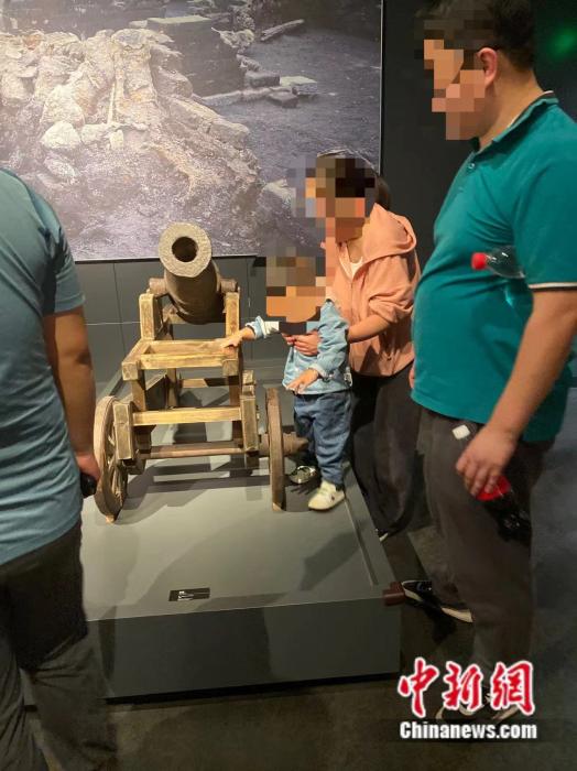 图为徐州博物馆内,有家长抱着孩子触摸馆内藏品.马壮 摄