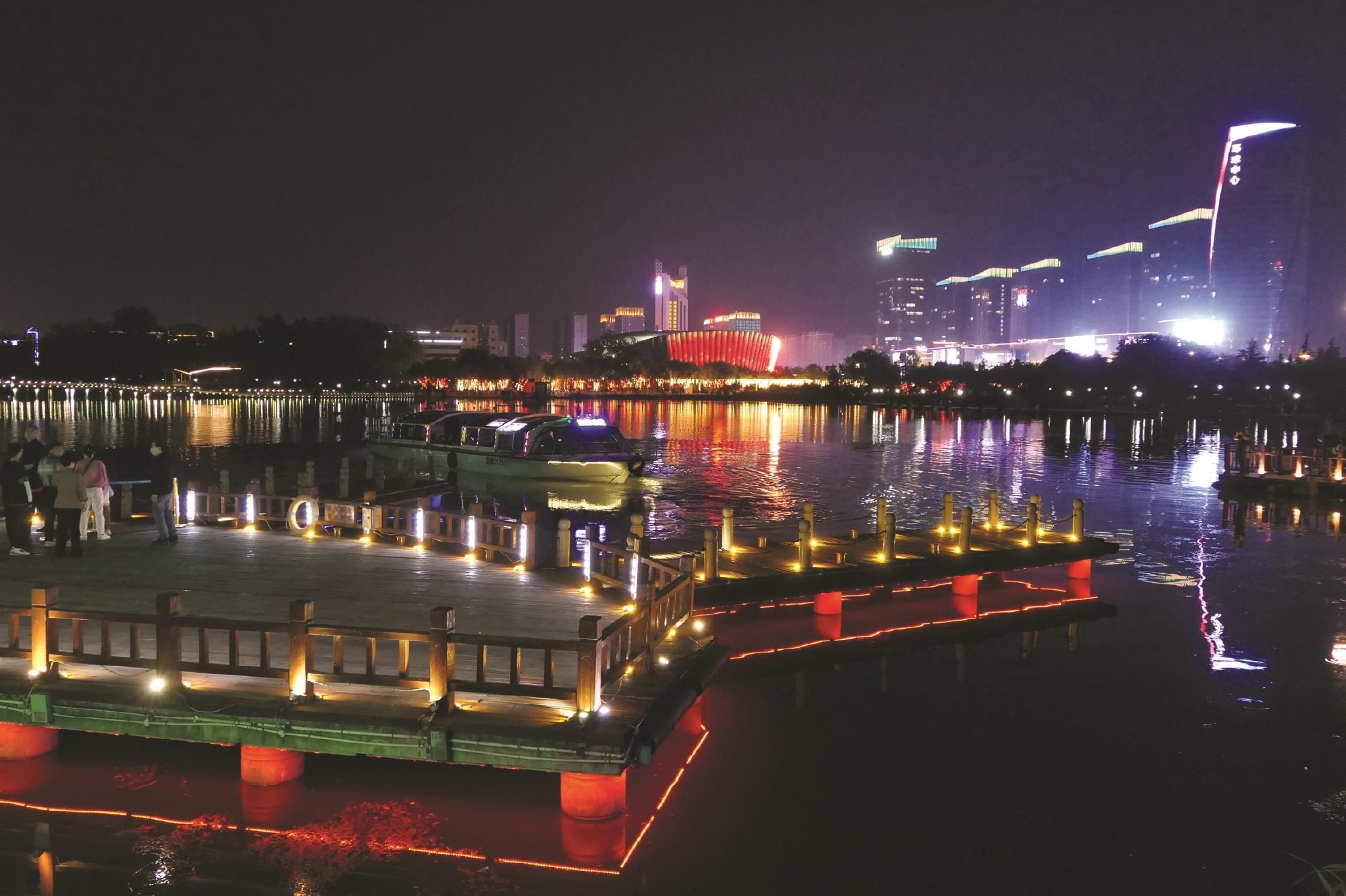 节日的夜晚灯光璀璨,图为5月2日游客在龙湖公园乘船游览城市美丽夜景.