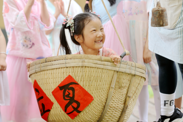 幼儿园组织小朋友们开展趣味称重,做花草蛋,捏立夏狗等传统民俗活动