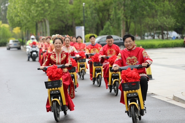 图注：山东阳信12对新人骑强国电单车参加集体婚礼