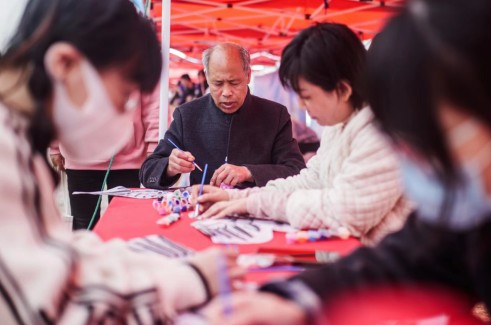 风筝非遗传承人杨付涛老先生与游客一起做风筝