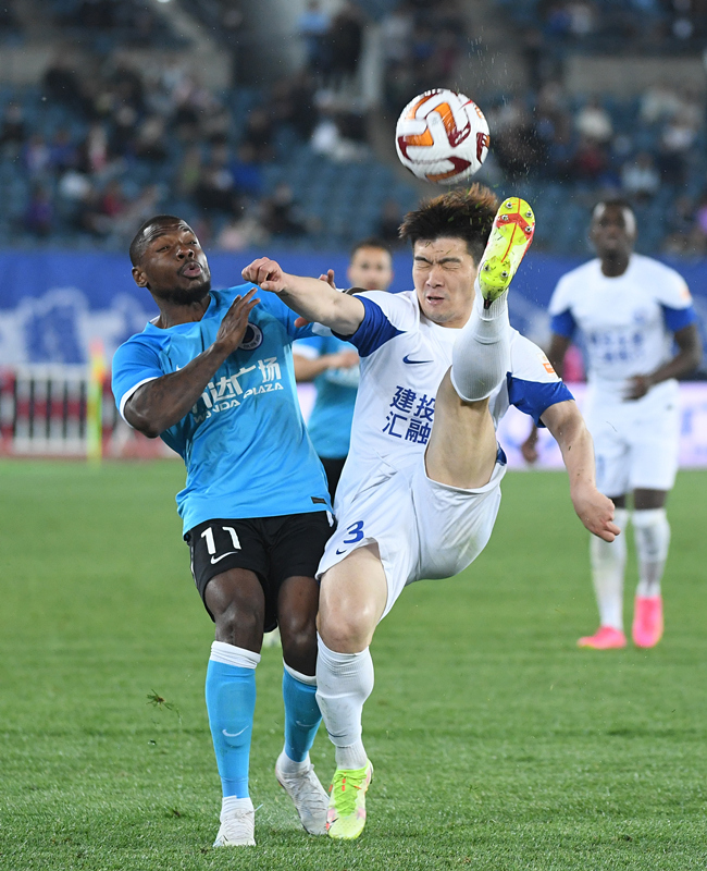 5月9日,大连人队球员曼巴(左)与沧州雄狮队球员赵宏略在比赛中拼抢.